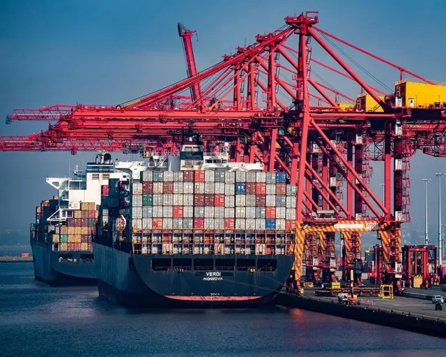 Trucks at a loading dock or containers at port, early morning, wide